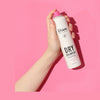holding Perfect Beauty Dry Shampoo Fresh Mango & Fruit on a pink background