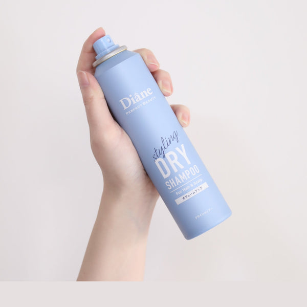 holding Perfect Beauty Styling Dry Shampoo Volume Up with white background