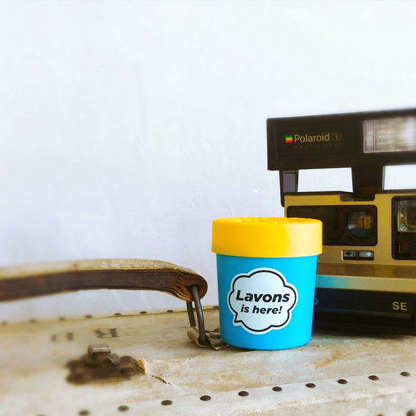 LAVONS Car Fragrance Gel Luxury Relax on top of old suit case